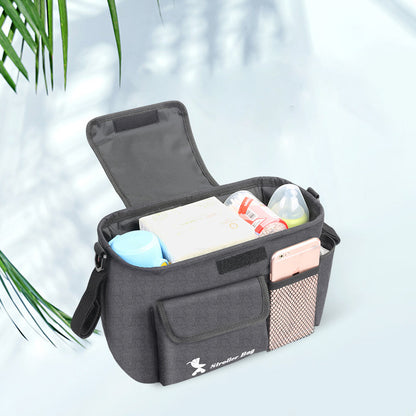 Black diaper bag with baby items on a light background