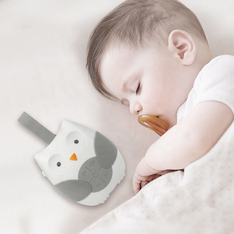 Baby sleeping with a soft toy next to them on a light background