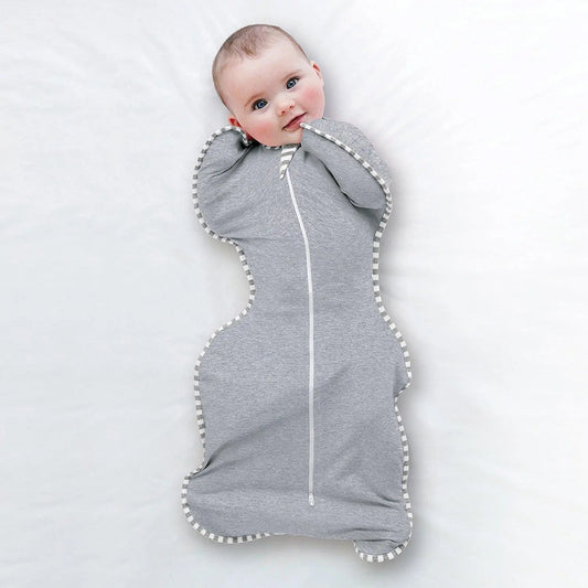 Baby wrapped in a gray swaddle with white trim on a light background