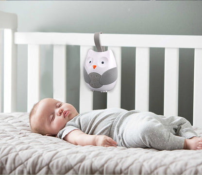 Baby sleeping in a crib with an owl-shaped mobile above